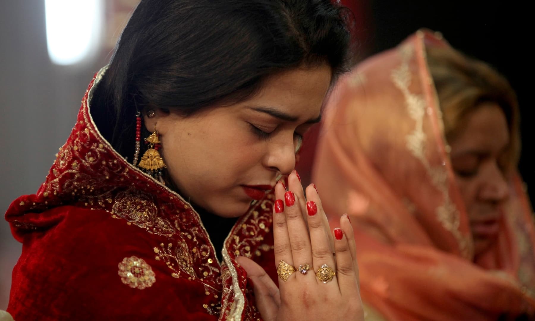 A Christian woman prays during Christmas mass in Sacred Heart Cathedral in Lahore. — AP