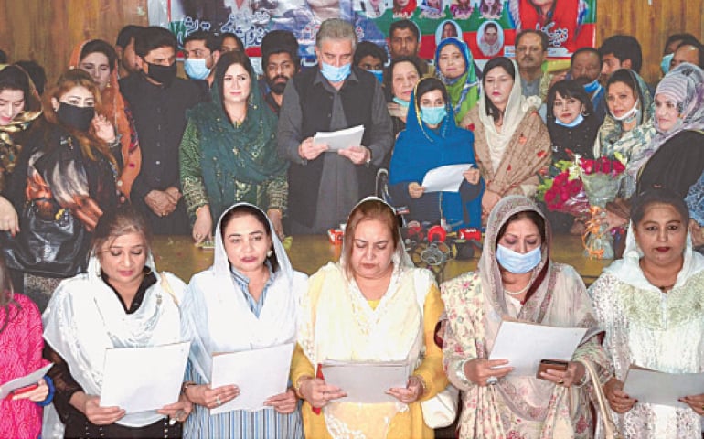 Foreign Minister Shah Mehmood Qureshi administers the oath to members of the PTI’s women wing of Multan district and minority members during a ceremony on Sunday.—INP