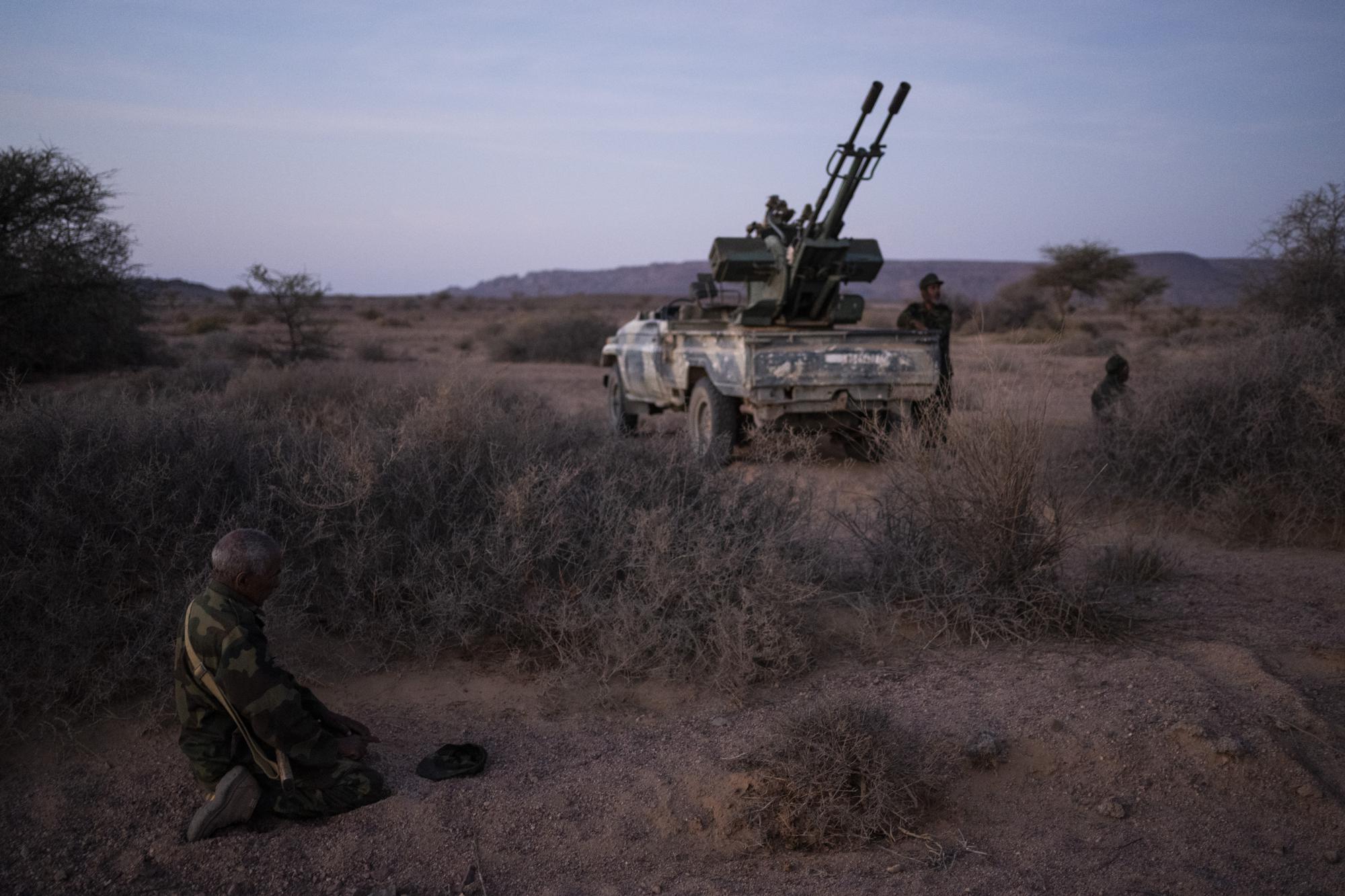 Polisario Front elderly soldier prays during a shooting exercise, near Mehaires, Western Sahara, Wednesday, Oct. 13, 2021. For nearly 30 years, the vast territory of Western Sahara in the North African desert has existed in limbo, awaiting a referendum that was supposed to let the local Sahrawi people decide their future. On one side, the Polisario Front wants the territory to be independent, while Morocco claims the area for itself. (AP Photo/Bernat Armangue)