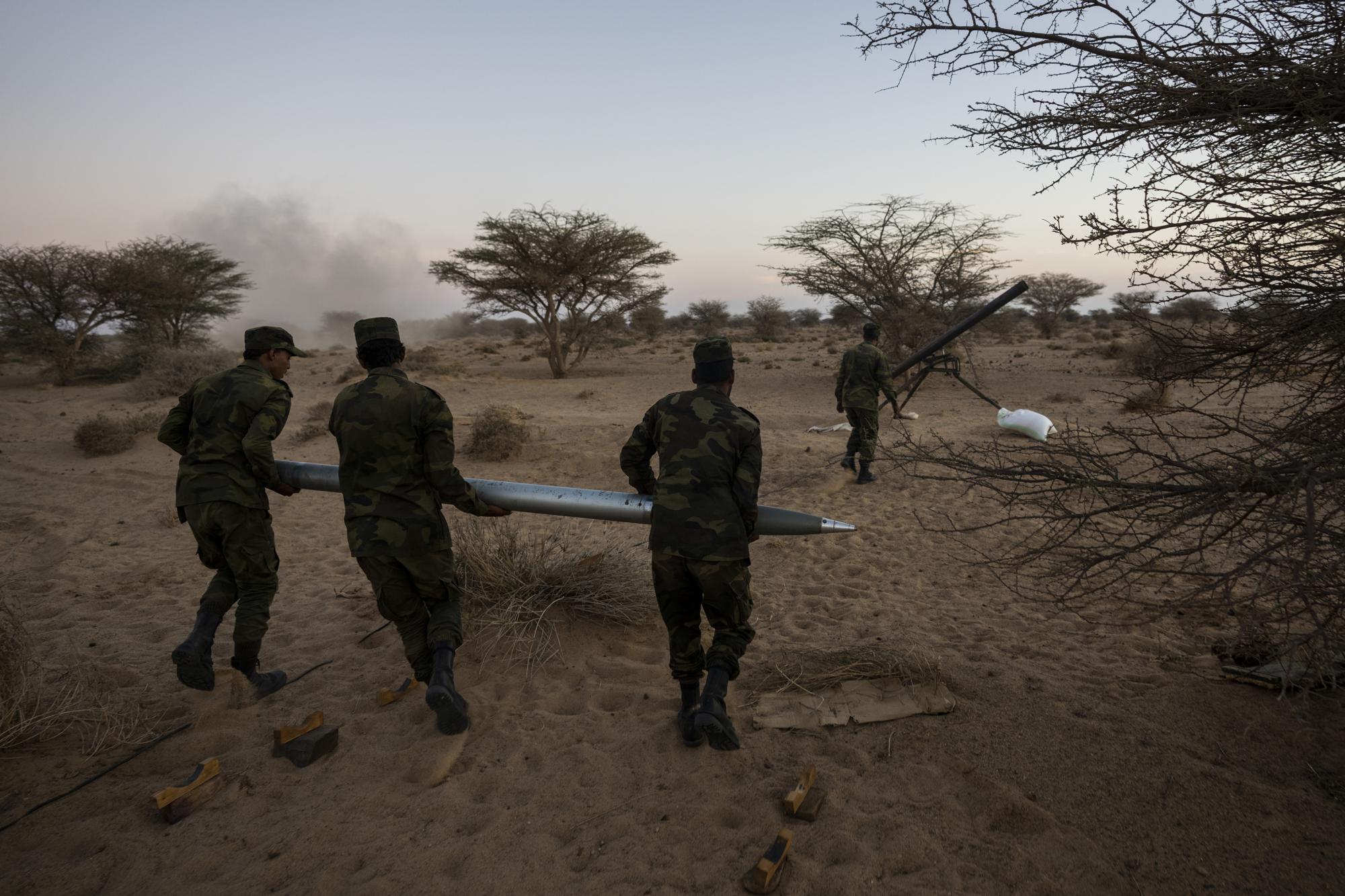 Polisario Front soldiers carry a rocket during an attack against Morocco, near Mehaires, Western Sahara, Thursday, Oct. 14, 2021. After 30 years of ceasefire, the Polisario Front has taken up arms again in its quest for an independent Western Sahara. The flaring up of the conflict is fueled by frustration among new generations of Sahrawi refugees who believe that the wait for a referendum on self-determination, as promised by the United Nations, has only played on Morocco's benefit while their lives languished in the unforgiving desert camps. (AP Photo/Bernat Armangue)