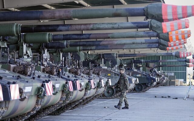 German soldiers walk beside tank howitzers 2000 at the Bundeswehr army base in Munster, northern Germany, Feb. 14, 2022. (Martin Meissner/AP)