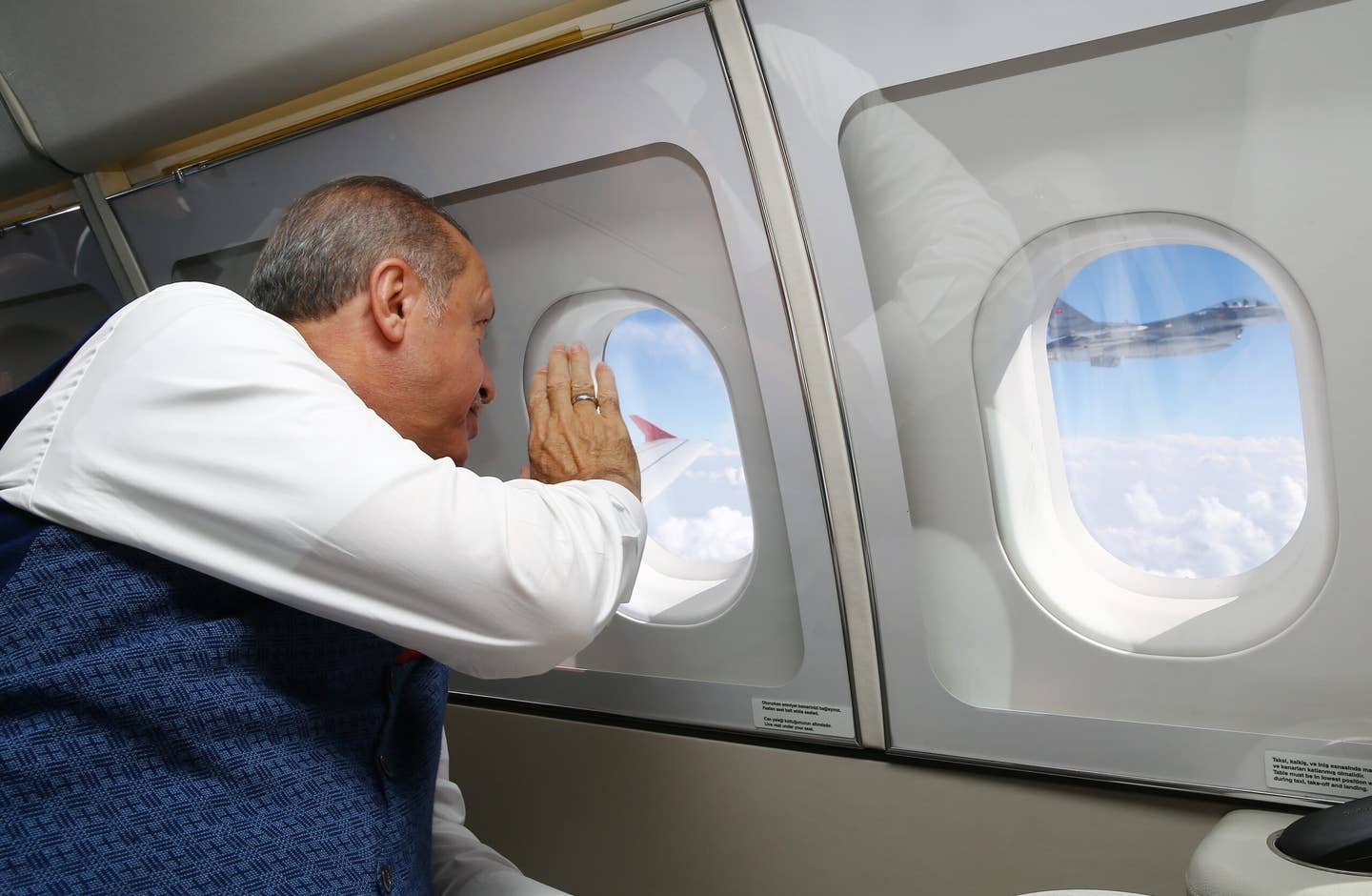 President of Turkey Recep Tayyip Erdogan greets an F-16 during his air travel to attend events of the first anniversary of the July 15 defeated coup attempt in Istanbul, in Ankara, Turkey, on July 15, 2017. <em>Photo by Kayhan Ozer/Anadolu Agency/Getty Images</em>