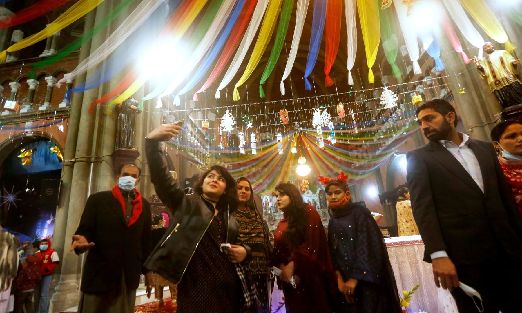 A girl takes a selfie after attending a Christmas mass in Sacred Heart Cathedral in Lahore, Friday. — AP