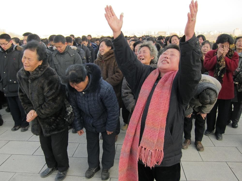 North Koreans cry and scream in a display of mourning for their leader Kim Jong Il at the foot of a giant statue of his father Kim Il Sung in Pyongyang, North Korea, after Kim Jong Il's death was announced Monday. (AP/APTN)