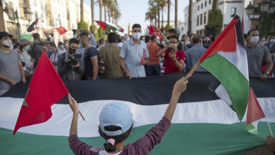 A young girl waves a Moroccan and a Palestinian flag during a protest against normalising of ties with Israel, in Rabat, Morocco, Friday, September. 18, 2020.