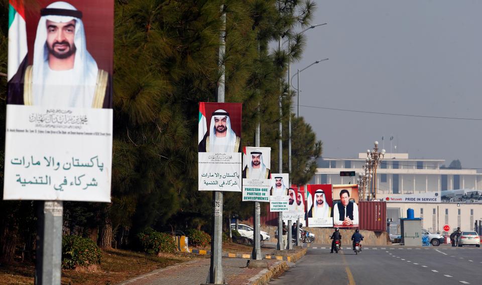 Motorcyclists ride past billboards showing the portraits of Abu Dhabi's Crown Prince, Sheikh Mohammed bin Zayed Al Nahyan, and Pakistani Prime Minister Imran Khan, in Islamabad, Pakistan, Sunday, Jan. 6, 2019.