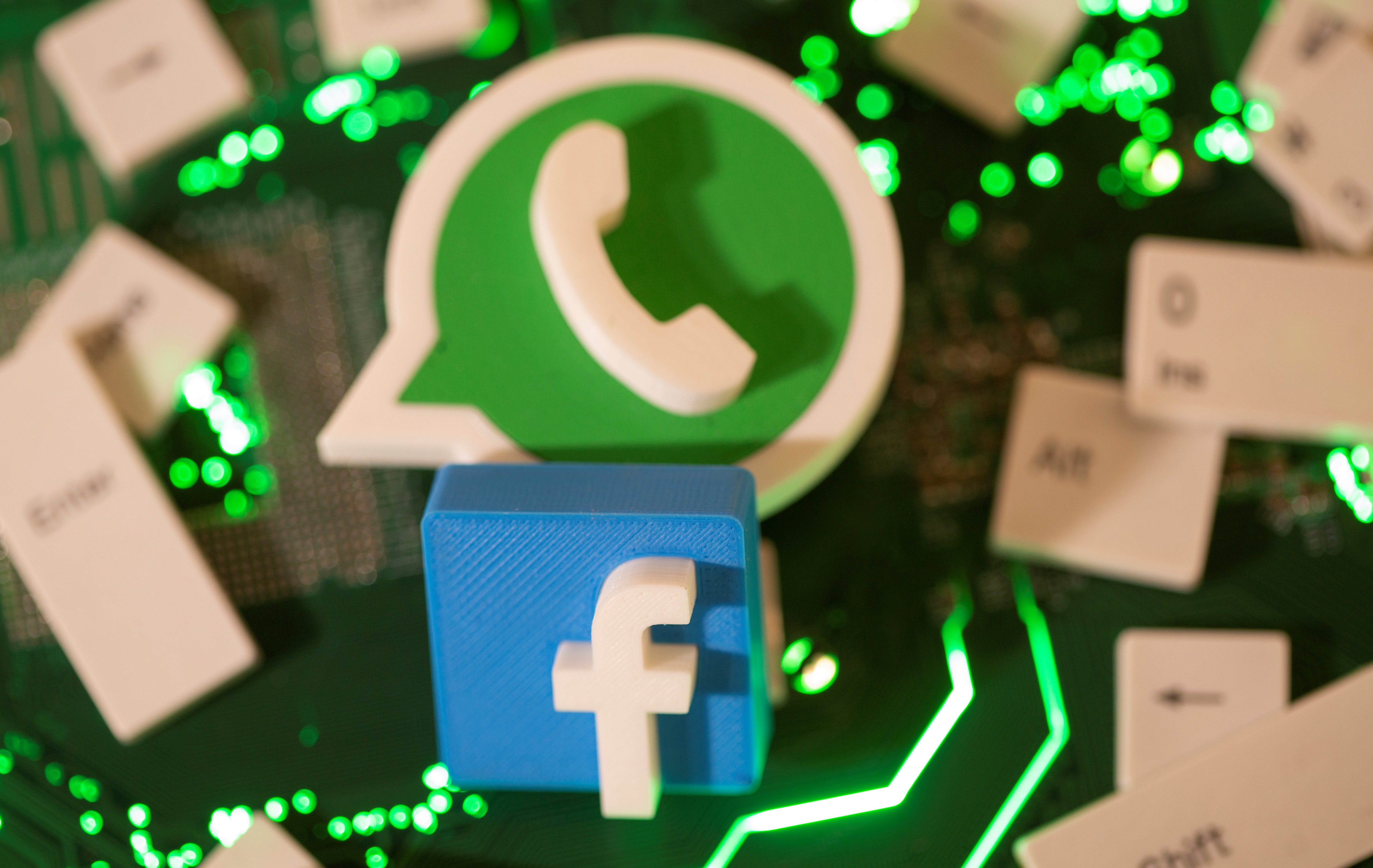 3D printed Facebook and WhatsApp logos and keyboard buttons are placed on a computer motherboard in this illustration taken January 21, 2021. REUTERS/Dado Ruvic/File Photo