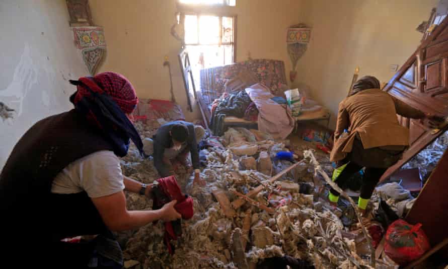 people looking through bombed-out home
