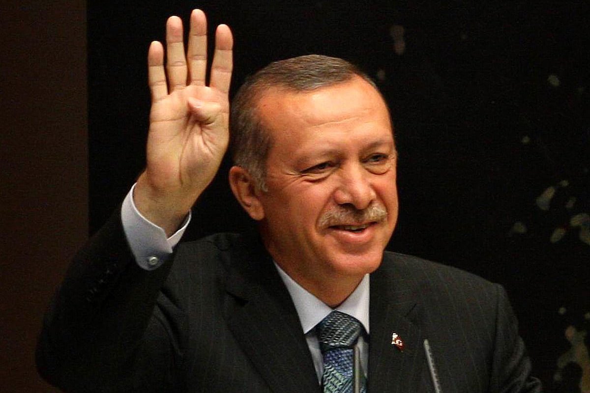 Turkey's Prime Minister Tayyip Erdogan flashes the Rabaa salute as he gives a speech during a meeting at his ruling Justice and Development Party (AKP) party headquarters in Ankara, on 20 August 2013. [ADEM ALTAN/AFP via Getty Images]