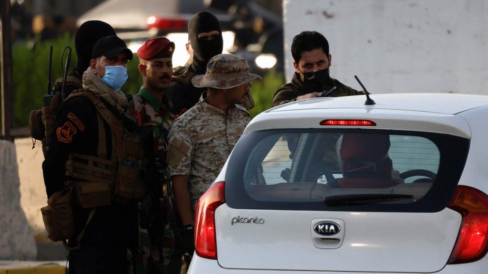 Popular Mobilisation Forces inspect a vehicle at an entrance to Baghdad's Green Zone on 26 May 2021