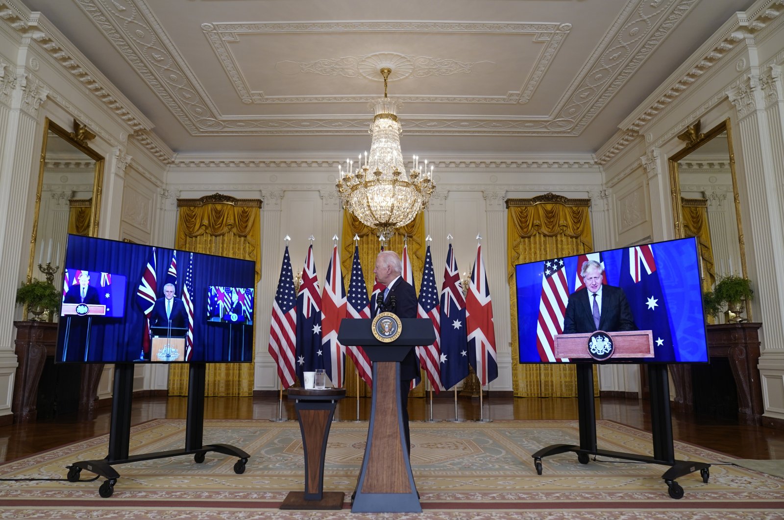 U.S. President Joe Biden, listens as he is joined virtually by Australian Prime Minister Scott Morrison, left, and British Prime Minister Boris Johnson, speaks about a national security initiative in the East Room of the White House in Washington, Wednesday, Sept. 15, 2021. (AP Photo)