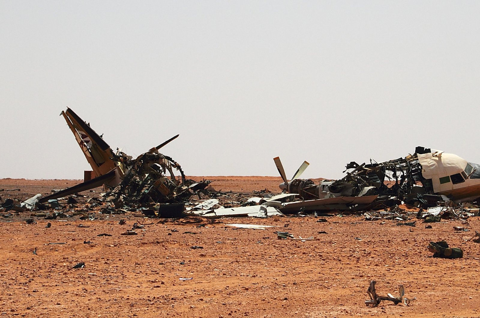 The wreckage of a plane is scattered in the desert outside a military base approximately 45 kilometers outside of Bani Walid, Libya, Saturday, Sept. 3, 2011. (AP File Photo)