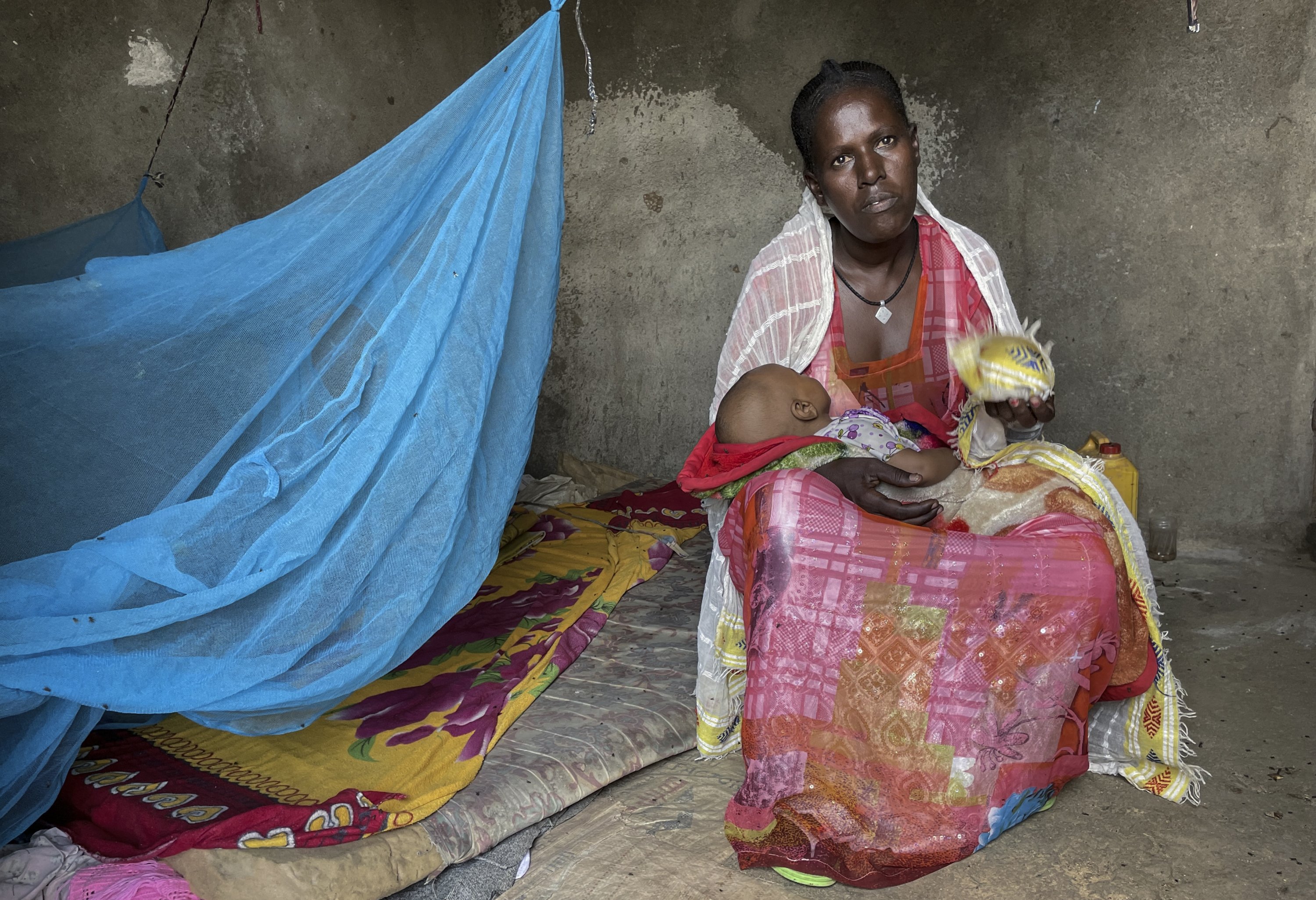 Letemariam, a mother of six, sits with her baby who was born in a former camp for Eritrean refugees now used by internally displaced Tigrayans, after escaping fighting in her hometown in western Tigray, in the Hitsats camp in the Tigray region, northern Ethiopia, Aug. 21, 2021. (AP Photo)