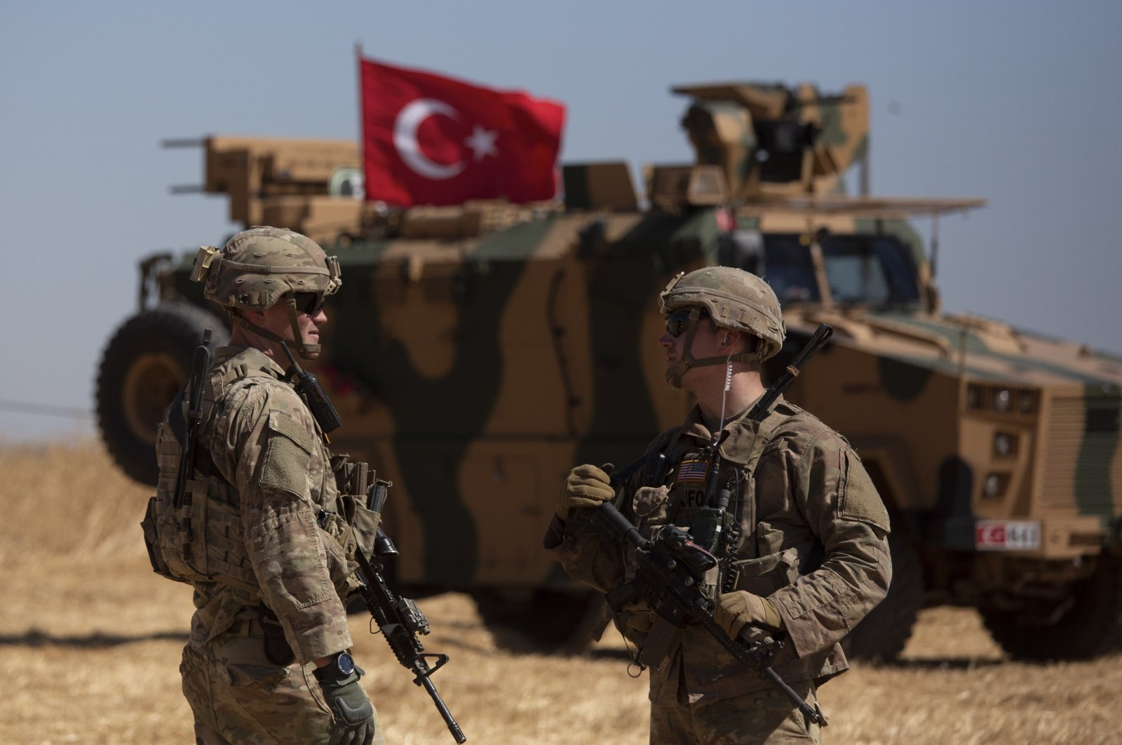 Soldiers stand near a Turkish armored vehicle during the first American-Turkish joint patrol in the so-called safe zone on the Syrian side of the border with Turkey near Tal Abyad, Syria, Sept. 8, 2019. (AP File Photo)