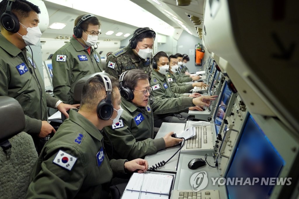 President Moon Jae-in (C) inspects South Korea's combat readiness aboard a Peace Eye aircraft during its two-hour patrol mission on Jan. 1, 2021, in this photo provided by his office.