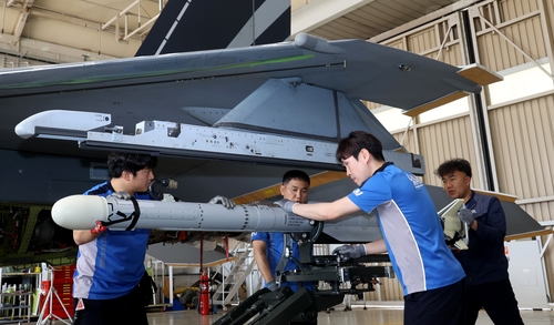 Korea Aerospace Industries Ltd. (KAI) workers equip a mock AIM-2000 air-to-air missile on the wing of a KF-21 prototype at a hangar in the company's headquarters in Sacheon, 437 kilometers south of Seoul, on May 9, 2023. (Pool photo) (Yonhap)