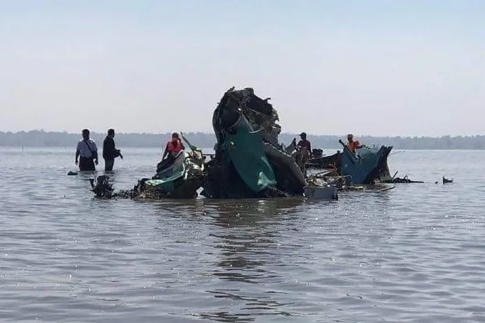 Recovery workers recover wreckage in a lake where a jet fighter crashed in the Sagaing region of Myanmar Wednesday, Feb. 16, 2022. The jet crashed into the lake Wednesday during a training flight in the country's northwest due to a malfunction, state-run media reported. (Khit Thit Media via AP)