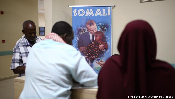 Somalians at a hospital reception with a poster of Erdogan holding a baby.