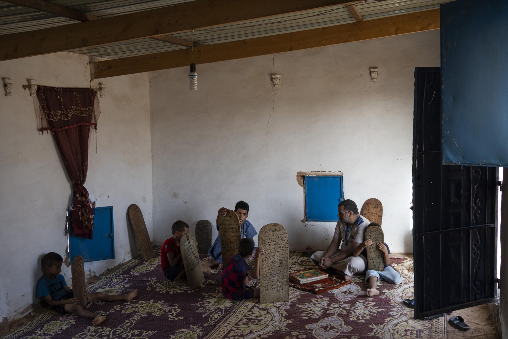 Sahara refugee Abdasalam Mostafa, 37, teaches Quran, Islam's holy book, at a madrasa in the Boujdour refugee camp, Algeria, Friday, Oct. 15, 2021. (AP Photo/Bernat Armangue)
