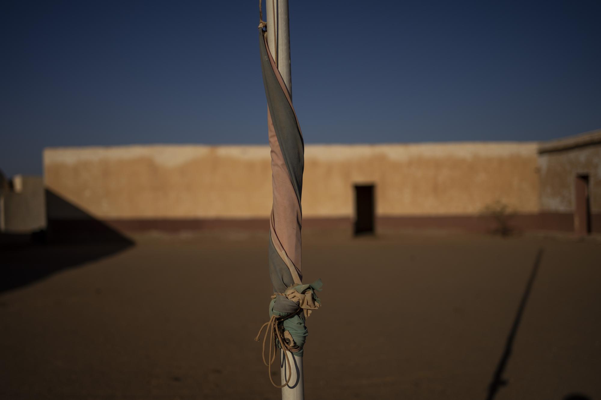 A Sahrawi flag is wrapped around a post in a closed school in Bir Lahlou, Western Sahara, Wednesday, Oct. 13, 2021. (AP Photo/Bernat Armangue)