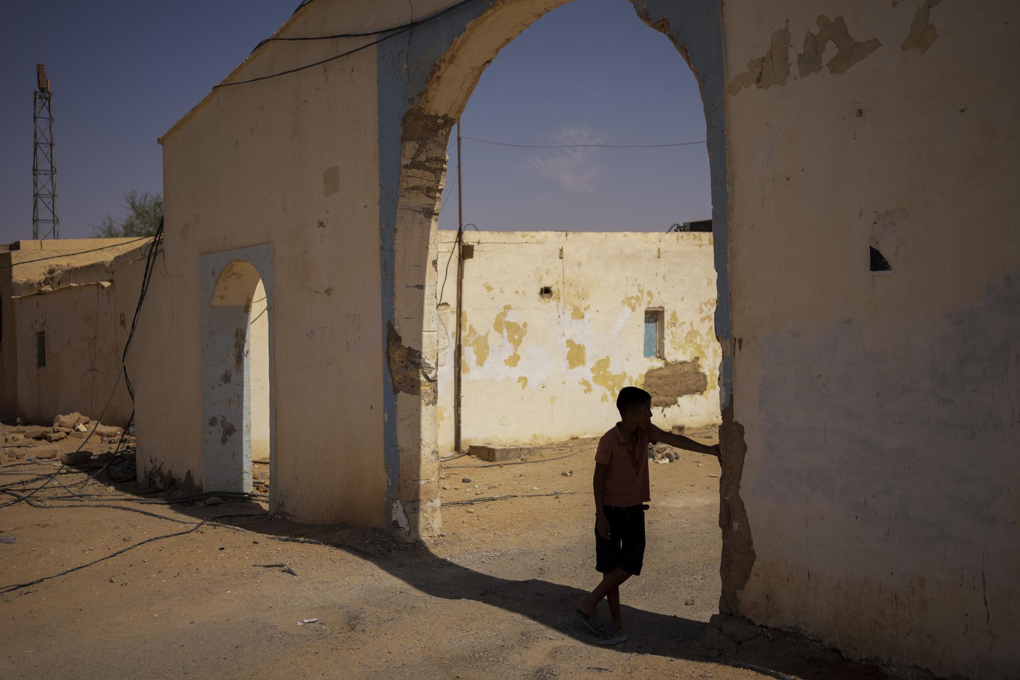 A Sahrawi refugee boy stands in the shadow in the Boujdour refugee camp, Monday, Oct. 11, 2021. (AP Photo/Bernat Armangue)
