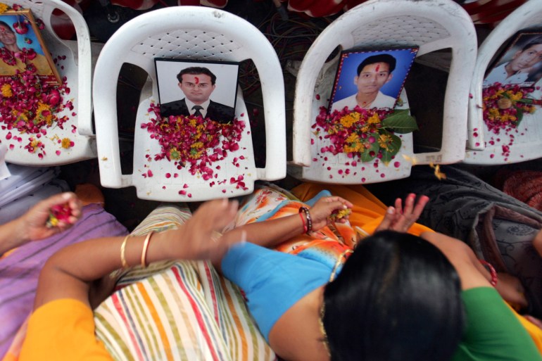 Family members of the 2008 Ahmedabad bombing victims look at photos of their loved ones during a prayer ceremony in Ahmedabad.