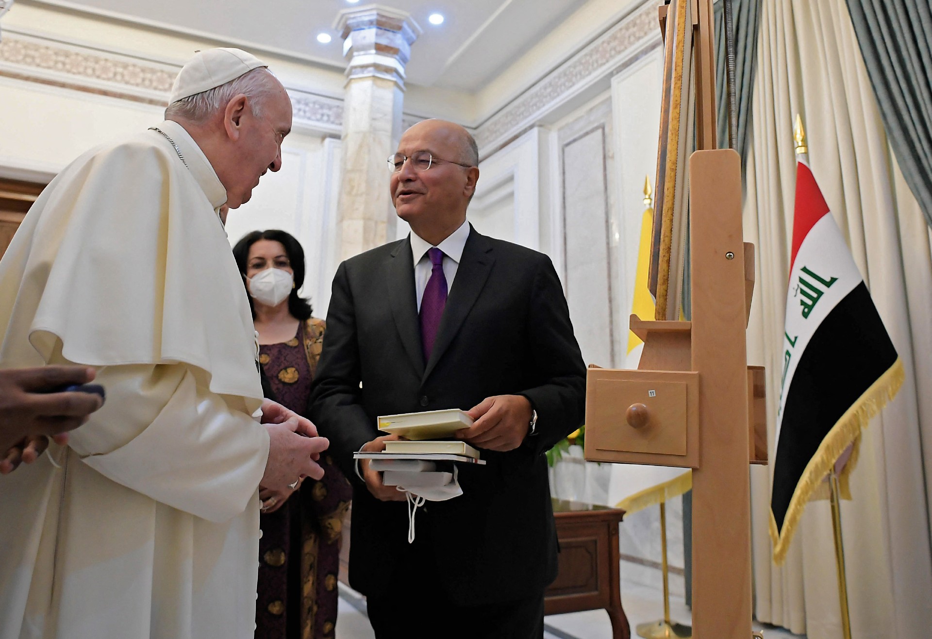 Iraqi President Barham Saleh offering books and other gifts to Pope Francis during his visit to the presidential palace in Baghdad's Green Zone on 5 March (AFP)